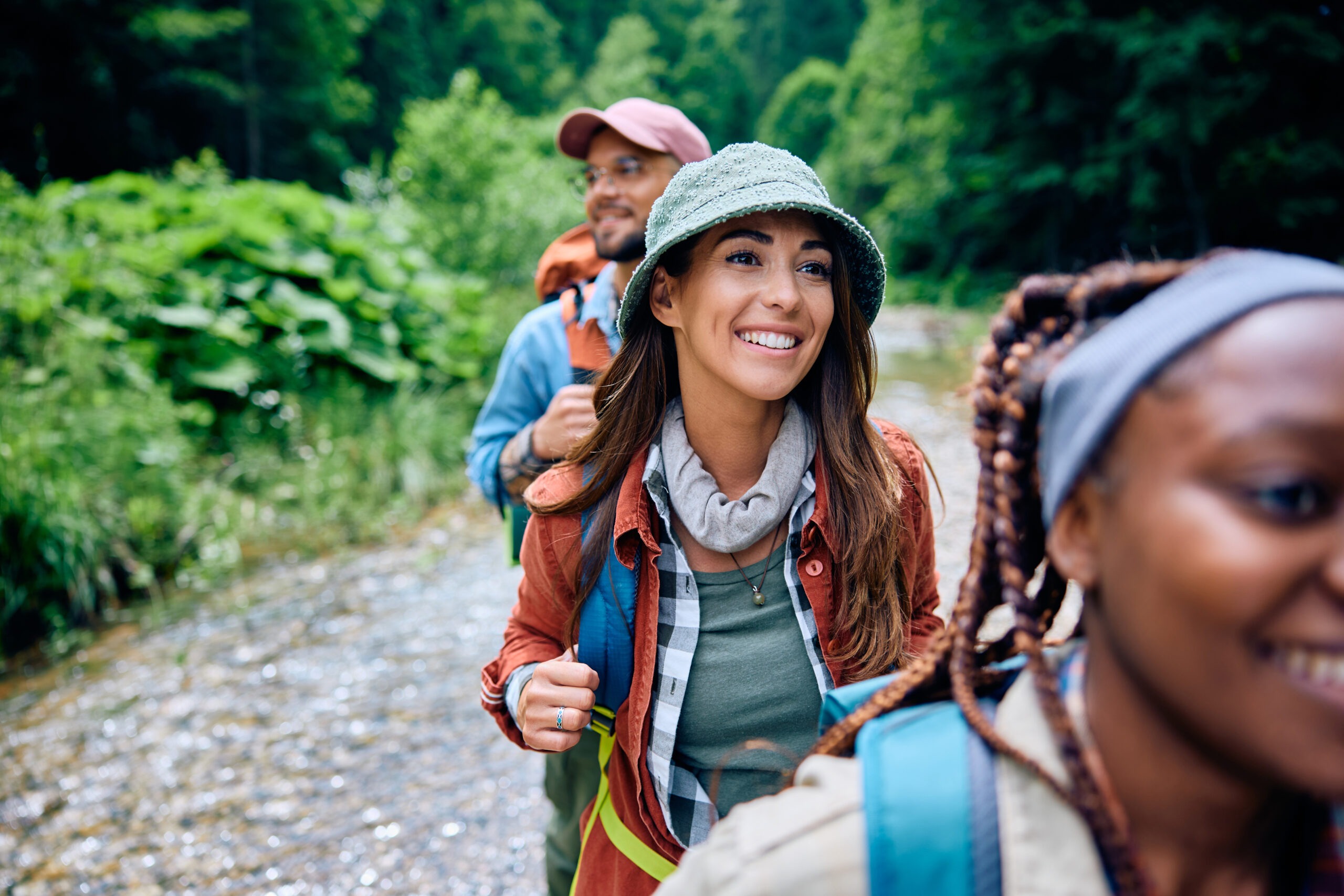 Happy woman enjoying in hiking with her friends in the woods